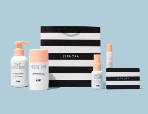 Three blume products in front of a Sephora gift bag with a baby blue background